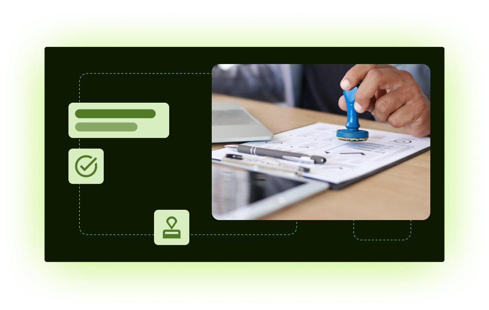 Approval stamp on paperwork beside laptop and tablet