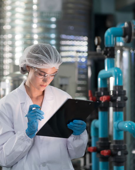 Lab technician records equipment readings in a processing facility