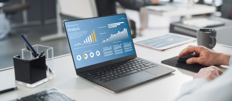 Laptop displaying pricing analysis dashboard on an office desk