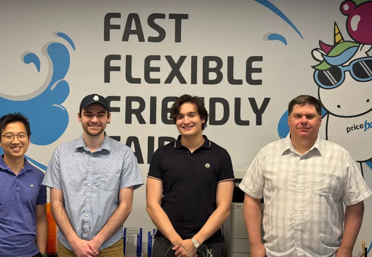 Four support engineers in front of Pricefx sign