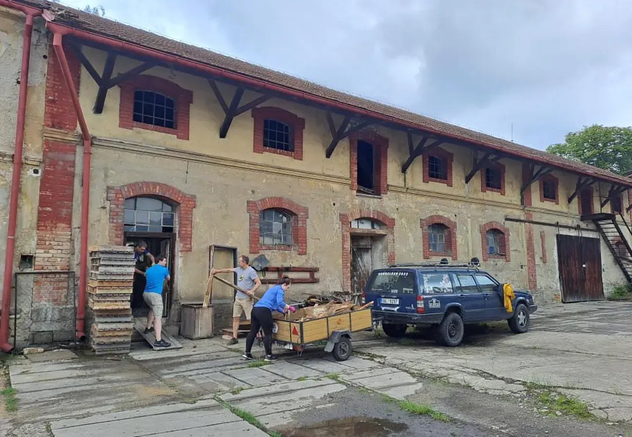 Pricefx employees clearing debris and cleaning up Chateau Pátek