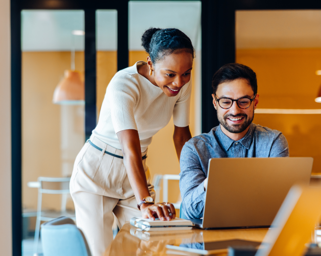 Two colleagues reviewing work together on a laptop in an office-1