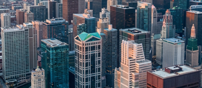 Aerial view of downtown skyscrapers clustered along a city riverfront