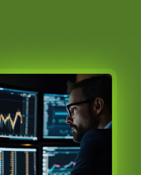 Analyst reviewing charts and dashboards across multiple monitors