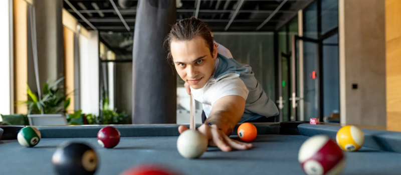 Colleague lining up a shot at a pool table in the office
