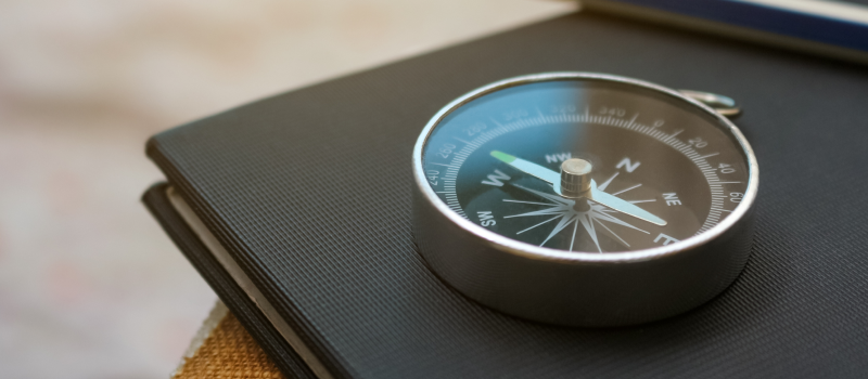 Compass on notebook beside a pencil, suggesting strategic direction1