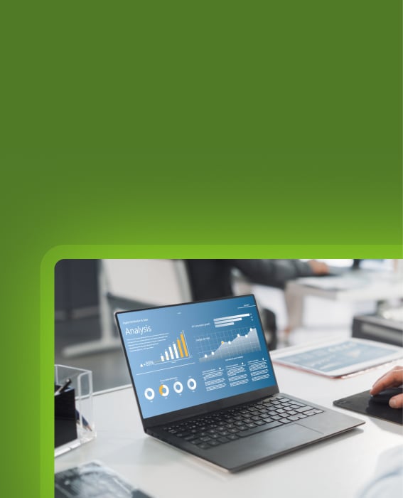 Laptop on desk displaying an analysis dashboard with charts and KPI widgets