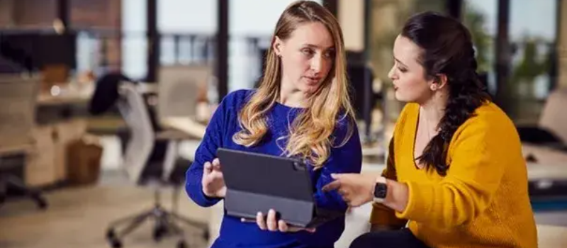 Two Pricefx employees discussing candidate on tablet