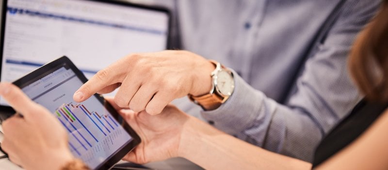 Colleagues reviewing chart data on a tablet during a discussion