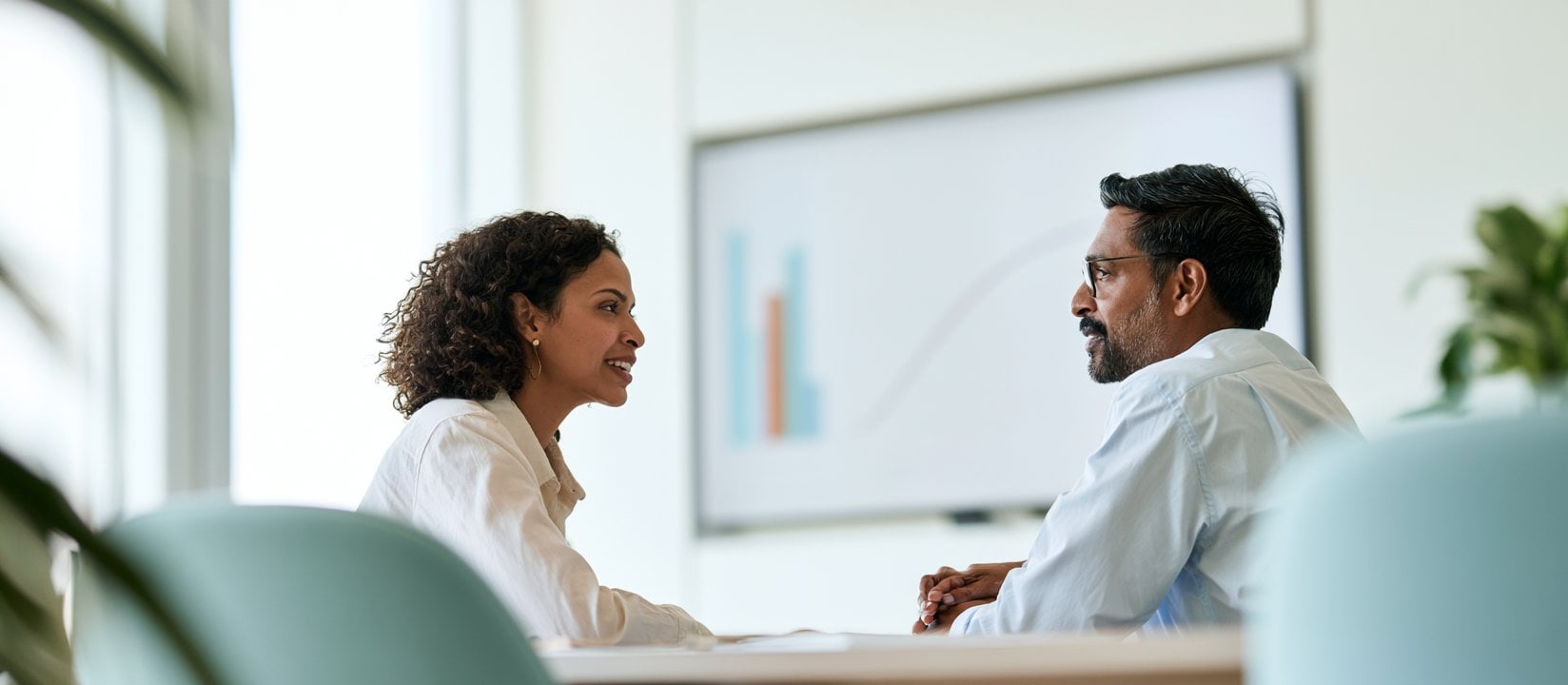 One-on-one conversation unfolds in front of a presentation screen