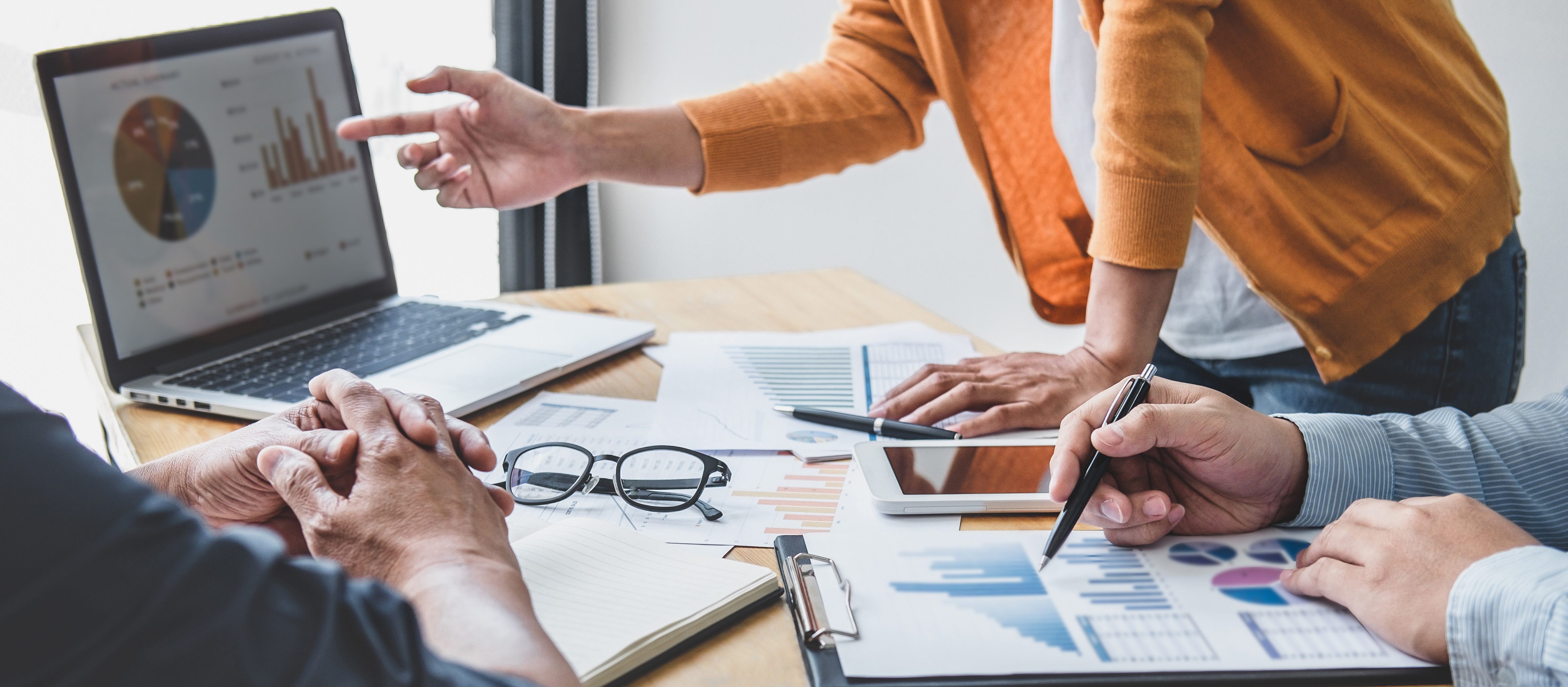 Team reviewing charts and reports during a business performance meeting