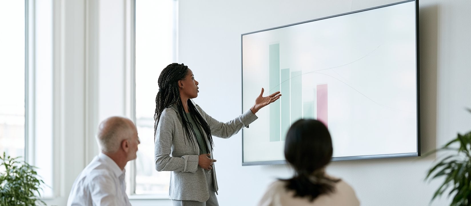 Two teammates talk through chart findings across a conference table-1