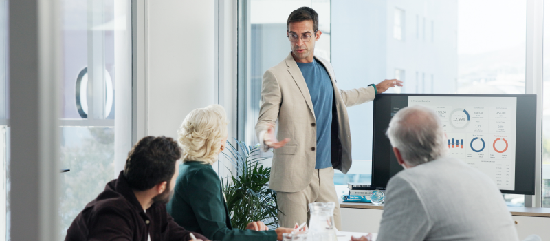 Presenter reviews performance dashboard with colleagues in a meeting1