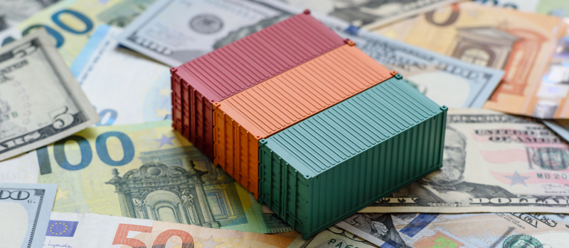 Shipping containers on mixed currencies, representing international trade costs1