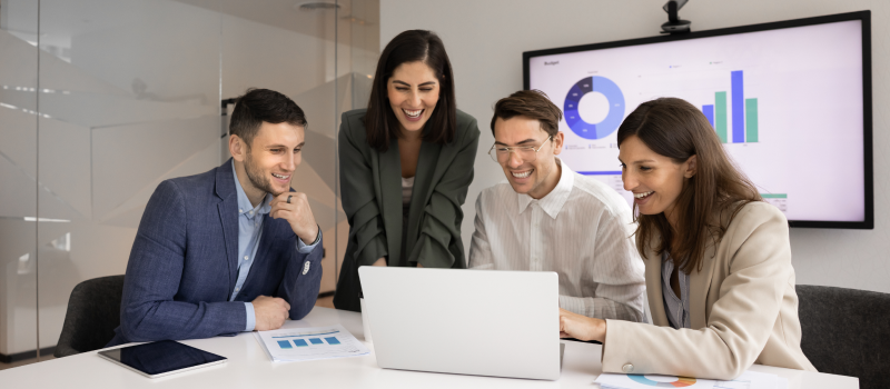 Team reviewing charts together on laptop in conference room