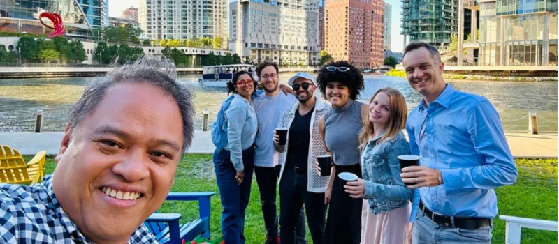 Team selfie at an outdoor gathering by the river