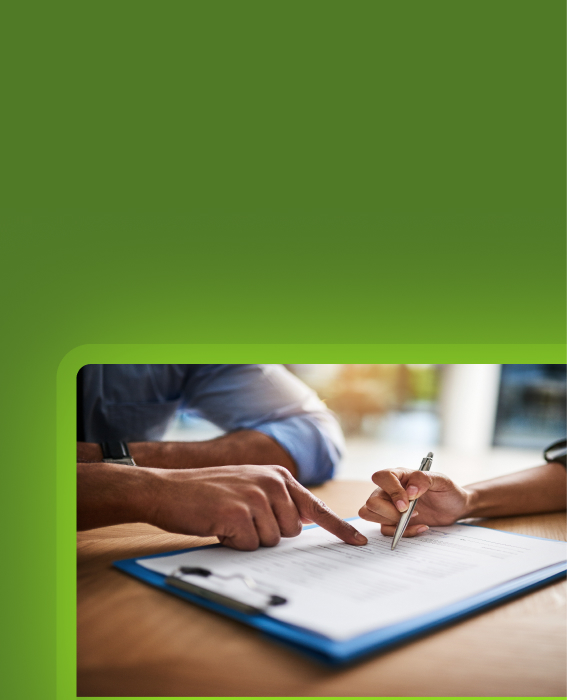Two people reviewing and signing a document on a clipboard