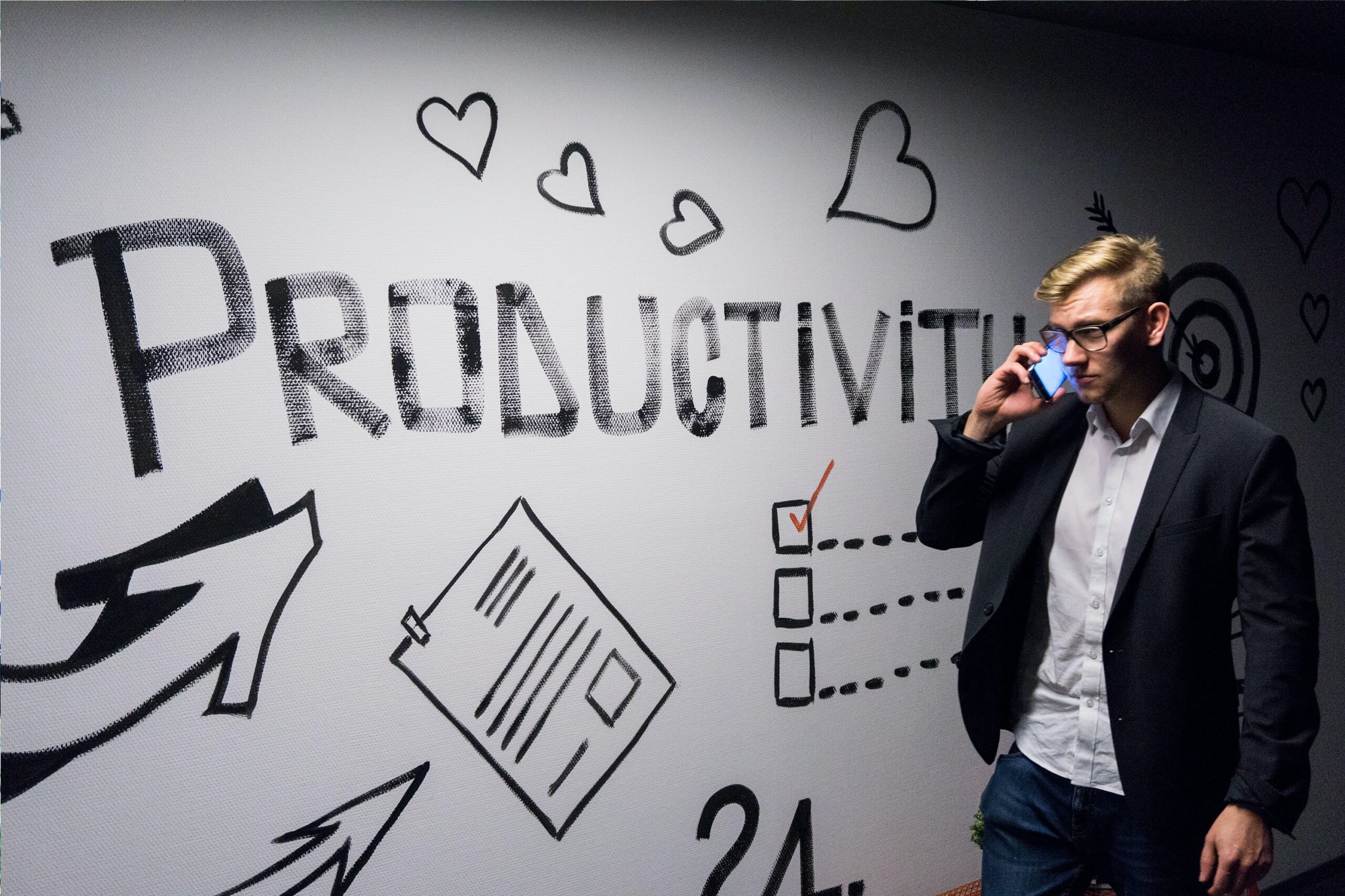 Manager-Speaking-On-Cell-Phone-In-front-of-Productivity-Whiteboard