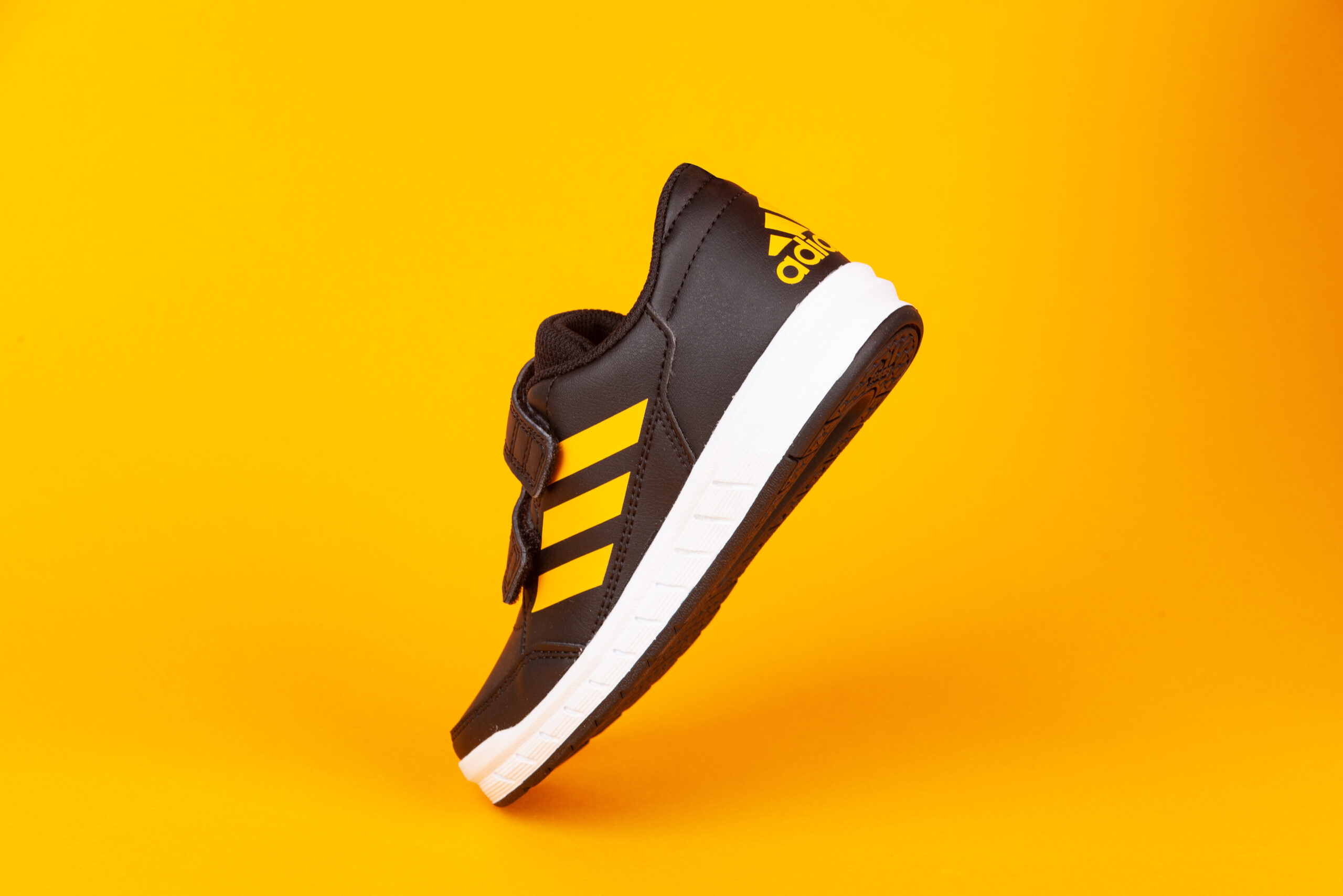 Adidas-black-and-yellow-sports-shoe-on-yellow-background